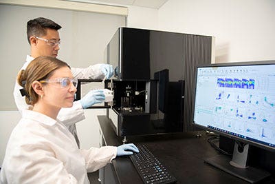 Two researchers working in a lab with the ID7000.