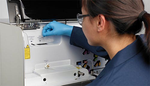 Lab technician inserting a sorting chip into the MA900.
