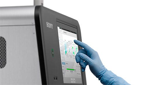 Researcher's handing interacting with the CGX10's touch screen display.